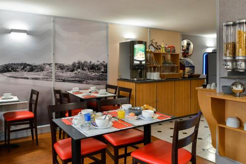 图尔卢瓦尔城堡之家酒店的一间带2张桌子和椅子的用餐室以及一间厨房