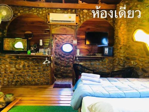 Ban Tha Phaeลีลา โฮมสเตย์ Leela Homestay的一间房子里带床和电视的房间