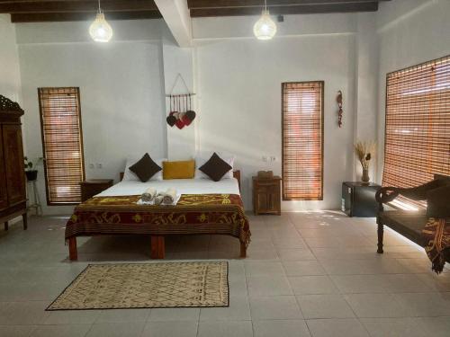 吉利特拉旺安Lutwala Bungalows and Private Villa的一间卧室设有床、两个窗户和一张沙发