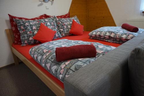 小莫拉夫卡Penzion a restaurace Na Hvězdě的宿舍间内的两张床,配有红色枕头