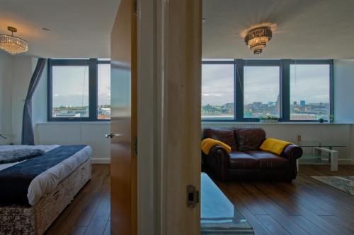 利物浦Bright & Comfortable 2-Bedroom Central Flat with Parking的一间卧室配有一张床、一张沙发和窗户。