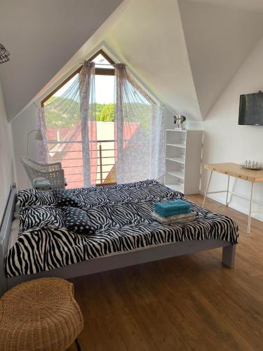 索利纳Solina Bieszczady Noclegi的卧室在窗户前配有斑马纹床