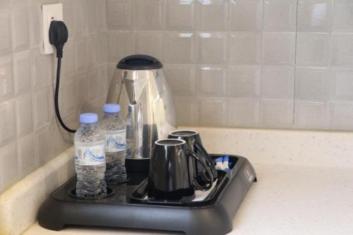 艾卜哈قمم بارك Qimam Park Hotel 2的厨房柜台上的茶壶和瓶装水