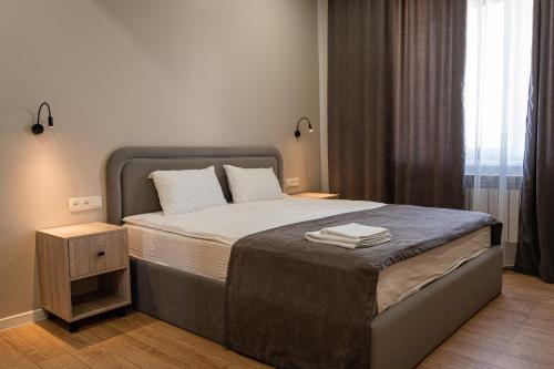 奇姆肯特BnB Hotel Shymkent的一间卧室配有一张大床和床头柜