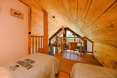 BarkocinKaszuby - Komfortowe domki nad jeziorem的客房设有一张床和木制天花板
