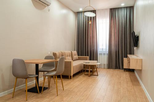 奇姆肯特BnB Hotel Shymkent的客厅配有桌子和沙发