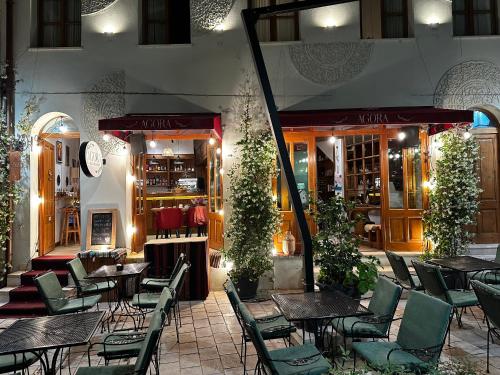 伏罗拉Agora Bed & Breakfast的一间带桌椅的餐厅和一间商店