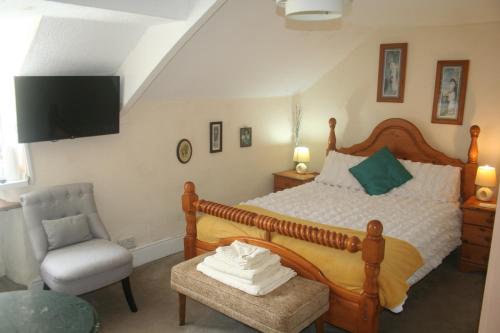 斯旺西Coynant Farm Guesthouse - Farm Park Stay的一间卧室配有一张大床和一把椅子