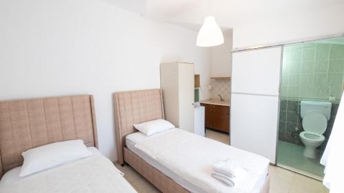 伯萨Huzur Pansiyon ve Cay Bahcesi的客房设有两张床和一间带卫生间的浴室。