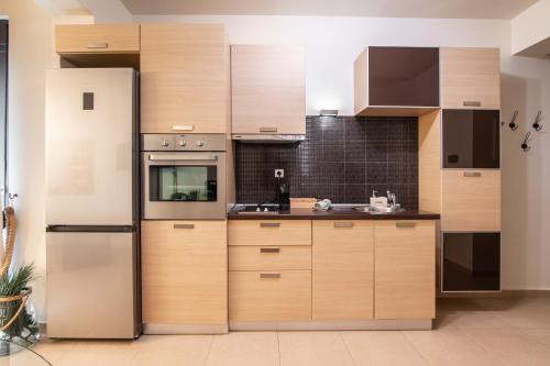 亚历山德鲁波利斯Nefeli Residence的厨房配有木制橱柜和冰箱。