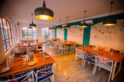 阿格拉Dá Bungalow - A Vacation Abode的餐厅设有木桌、椅子和窗户。