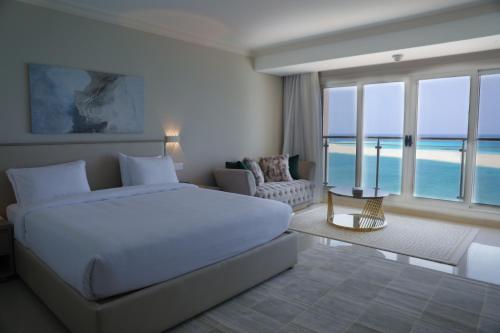 马特鲁港Triumph White Sands Hotel的卧室配有白色床,享有海景