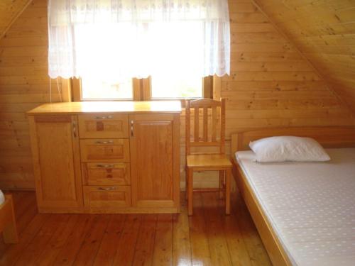 弗瓦迪斯瓦沃沃Domki Małgorzata的一间位于小屋内的卧室,配有一张床和一个窗户