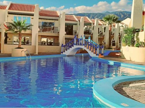 阿德耶paradise beach apartment的度假村内带蓝桥的游泳池