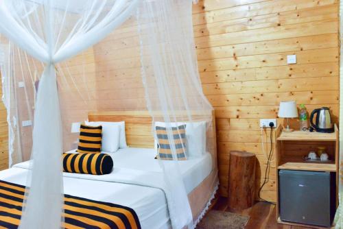 埃拉Eco Village的一间卧室配有一张带天蓬的床和一台电视