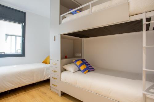 卡斯特尔德费尔斯Precioso apartamento en la playa的一间卧室设有两张双层床和一扇窗户。