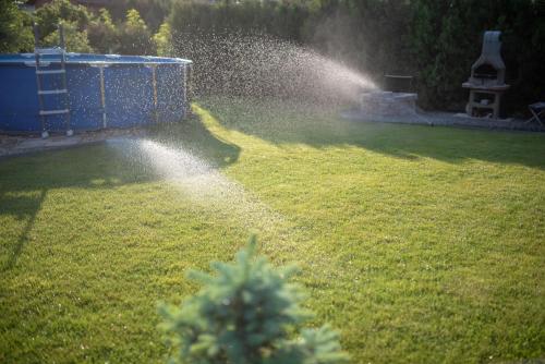 韦赖谢吉哈兹MaMaison的草地上有一个洒水的花园