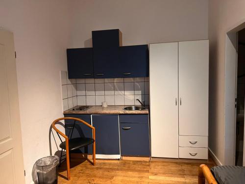 赫恩Pension-Sendis的一间小厨房,配有蓝色橱柜和椅子