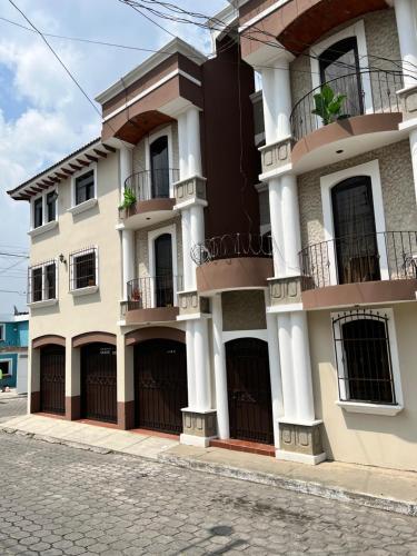 克萨尔特南戈Amplio Apartamento, en Colonia Cerezos, Tercer nivel的街道上带阳台的大型白色建筑