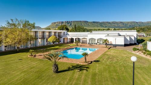 哈里史密斯African Sky Harrismith Inn的享有带游泳池的房屋的空中景致