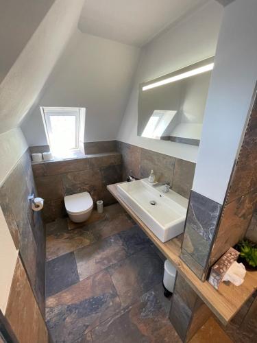 摩泽尔河畔的泽尔Hotel garni "Café im Hamm"的一间带水槽和卫生间的浴室
