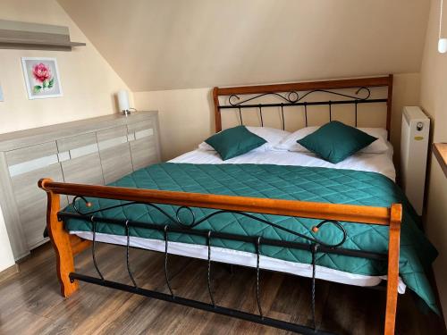 图拉瓦Zatoczka Turawa的一间卧室配有一张带绿色和白色床单的床