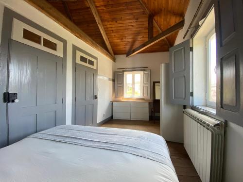 Vila Feliz的卧室配有白色的床和2扇窗户。