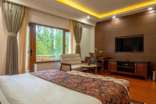 列城Hotel Gyalpo Residency - A Mountain View Luxury Hotel in Leh的配有一张床和一台平面电视的酒店客房