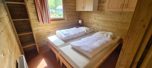 于尔克Vakantiepark 't Urkerbos - 5 persoons Brabantse blokhut的小木屋内带两张床的房间