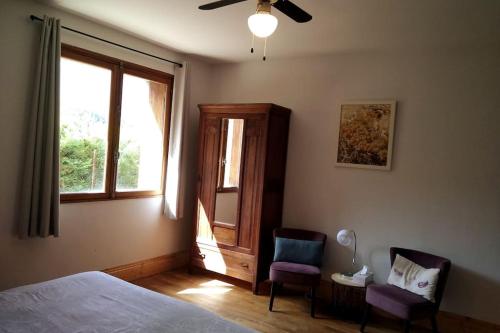 屈伊朗Spacious villa apartment with mountain view -2 bed的一间卧室配有一张床、两把椅子和一个窗户