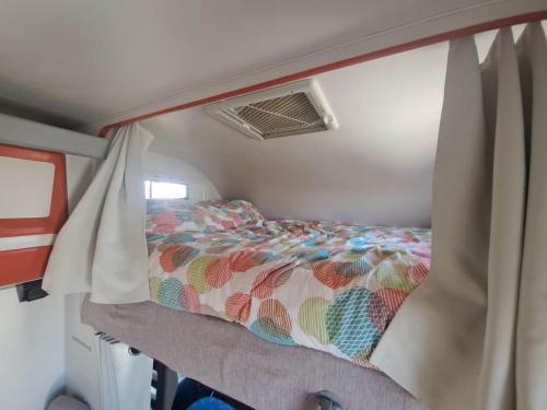布吕热莱特Camping car à 3 minutes du parc Pairi Daiza的卧室配有一张位于rv的床铺
