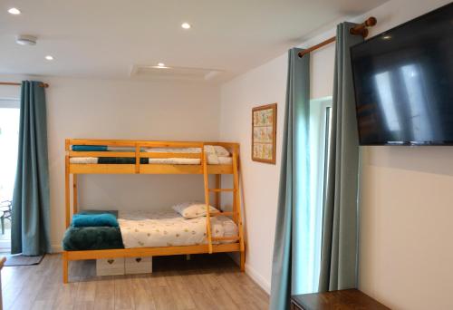 Family Retreat or Romantic Break的一间卧室配有两张双层床和电视