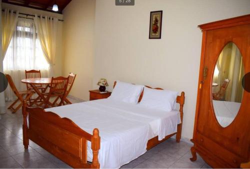 康提Reverie Hill Bungalow, Kandy的一间卧室配有一张大床和一张桌子及椅子