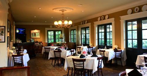 维克斯堡Anchuca Historic Mansion & Inn的餐厅配有桌椅和白色的桌布