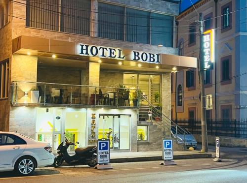 斯库台Bobi Hotel的停在酒店前面的摩托车建筑