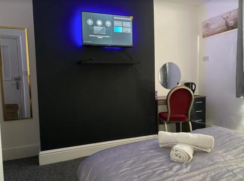 布莱克本Hotel Royal Blackburn的一间卧室配有一张床,墙上配有电视