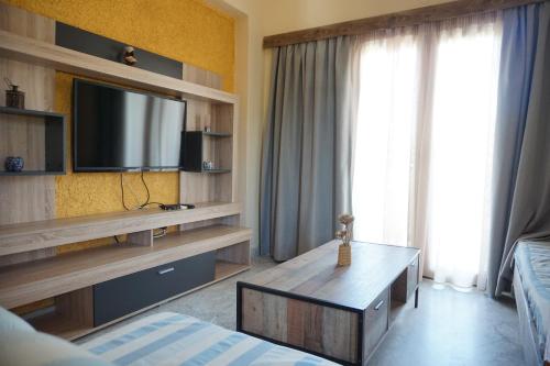 普拉坦斯卡泰里尼公寓酒店的客厅配有电视、床和桌子