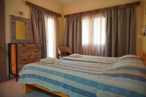 普拉坦斯卡泰里尼公寓酒店的卧室配有蓝色和白色的床和窗户。