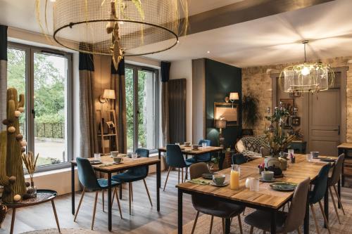 巴比松拉巴斯提德巴比松酒店的餐厅设有木桌、椅子和吊灯。