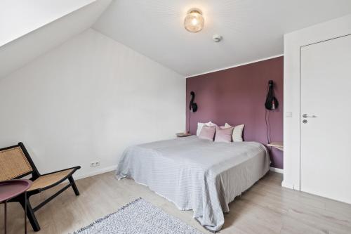 雷克雅未克Downtown Baldursbrá Holiday Home的卧室配有白色的床和紫色色调的墙壁