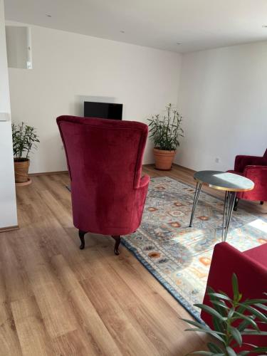 MellenseeSeeblick Apartment am Mellensee的客厅配有红色椅子和桌子