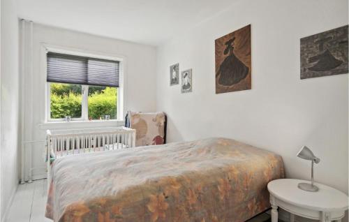 哥本哈根1 Bedroom Cozy Apartment In Valby的一间卧室配有一张床、一张桌子和一个窗户。