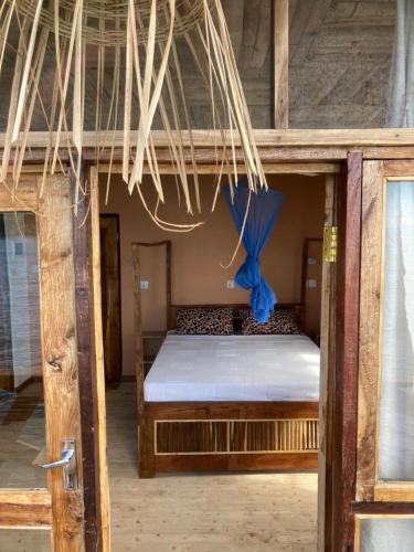 Nkhata BaySoul Rebel Lodge & Backpackers的一间卧室配有一张带蓝色丝带的双层床