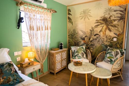 马赛Ô Balinais mini villa avec spa et piscine privatif的配有床和两把椅子及一张桌子的房间