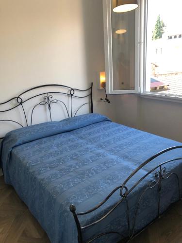 佛罗伦萨Leonardo luxury apartment的一间卧室配有一张带蓝色棉被的床和窗户。