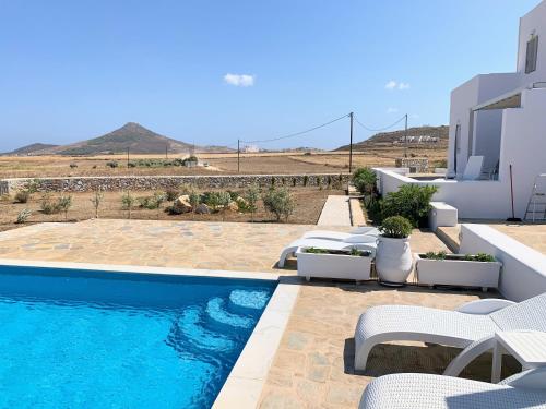 MármaraQuiet 2-bedroom sea view villa with shared pool的一个带椅子的游泳池以及一座房子