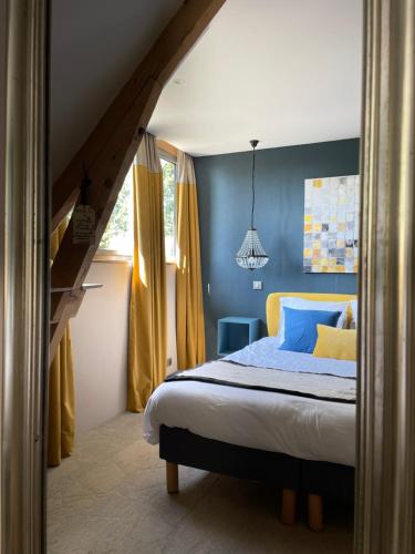 巴比松拉巴斯提德巴比松酒店的一间卧室配有一张蓝色墙壁和黄色窗帘的床