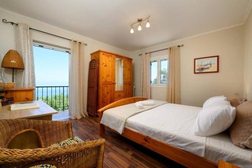 科孚镇Traditional Seaview Home Candili的一间卧室配有一张床、一张书桌和一个窗户。