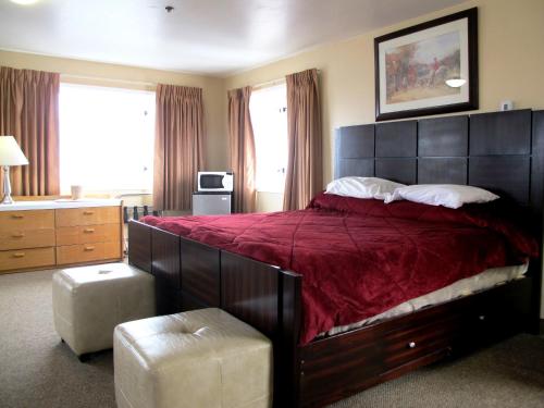 安克雷奇梅丽尔菲尔德酒店的一间卧室配有一张大床和红色的床罩