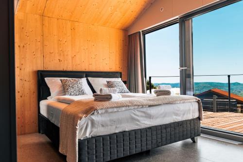 马来济格Wine Paradise - Glamping resort的一间卧室设有一张床和一个大窗户